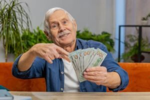abuelo sonriente recibiendo dinero en casa