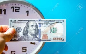 billetes de dolar y reloj analogico juntos