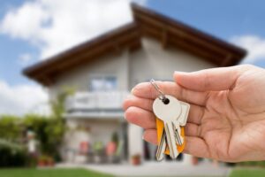 casa con manos sosteniendo llaves