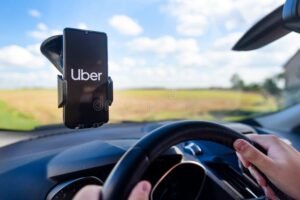 conductor de uber usando smartphone manejando coche