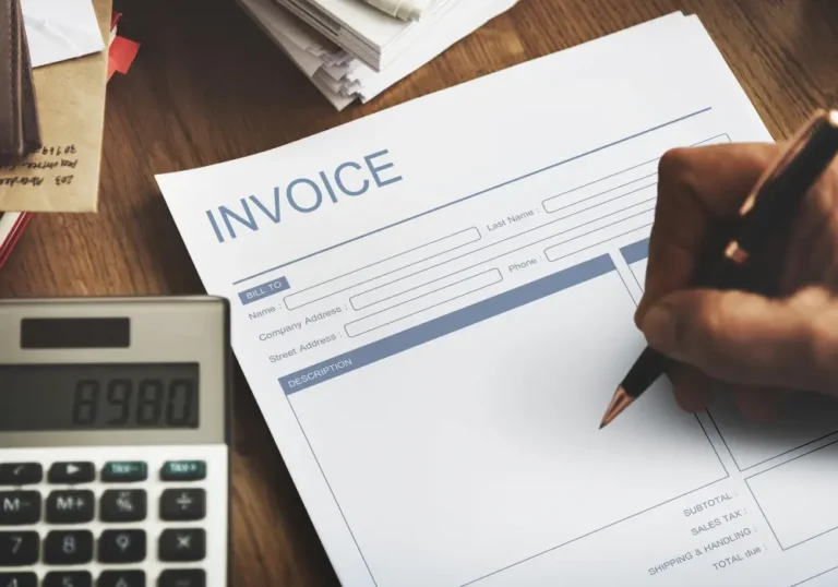 mano tachando factura impresa sobre escritorio