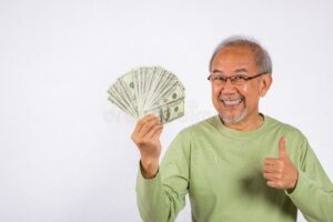 manos entregando dinero a jubilado sonriente