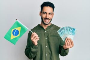 Cómo enviar dinero a Brasil usando Mercado Pago desde Argentina 38 manos entregando dinero con bandera brasil