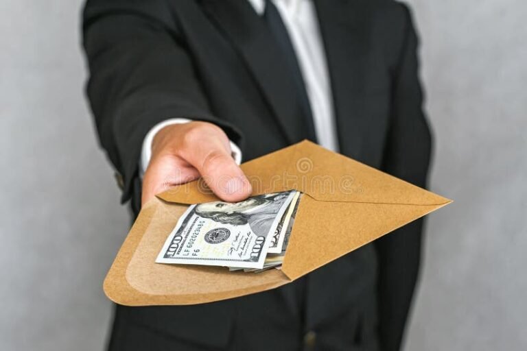 manos entregando un sobre de dinero