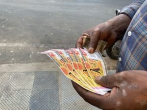 manos recibiendo billetes de loteria coloridos