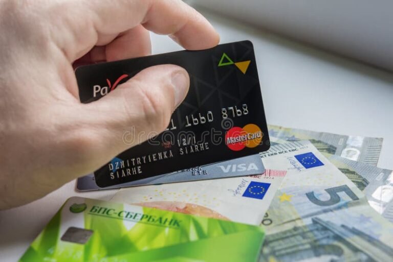 manos sosteniendo tarjeta paypal con billetes