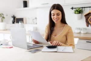 mujer feliz en casa con calculadora y documentos