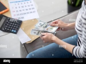 persona contando billetes junto a calendario