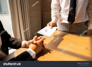 persona entregando carta de renuncia oficina