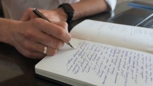 persona escribiendo en un cuaderno profesionalmente