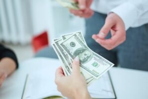 Cómo Anotarse Para El Bono De 50 Mil Pesos En Argentina 5 persona recibiendo dinero en mano