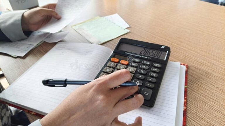 persona revisando documentos y calculadora en escritorio