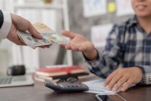 persona usando celular con billetes argentinos