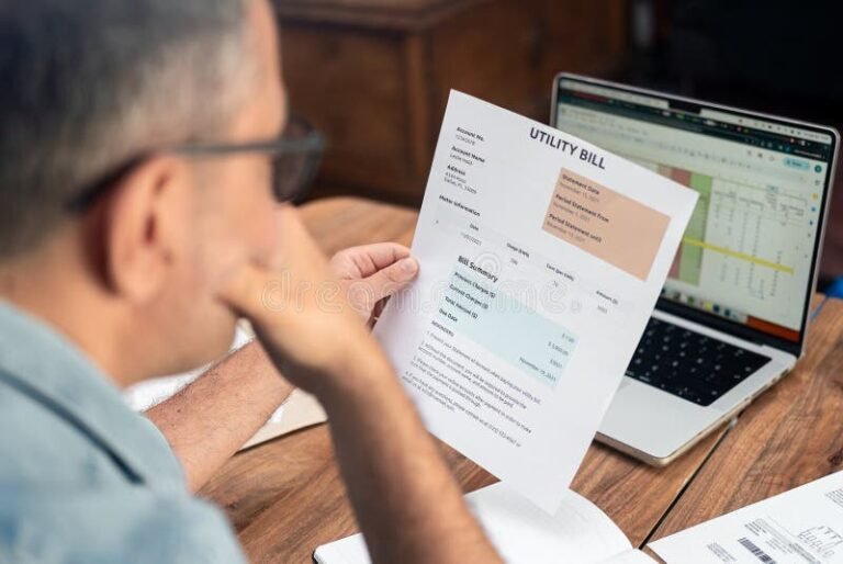 persona usando computadora y factura de servicios publicos
